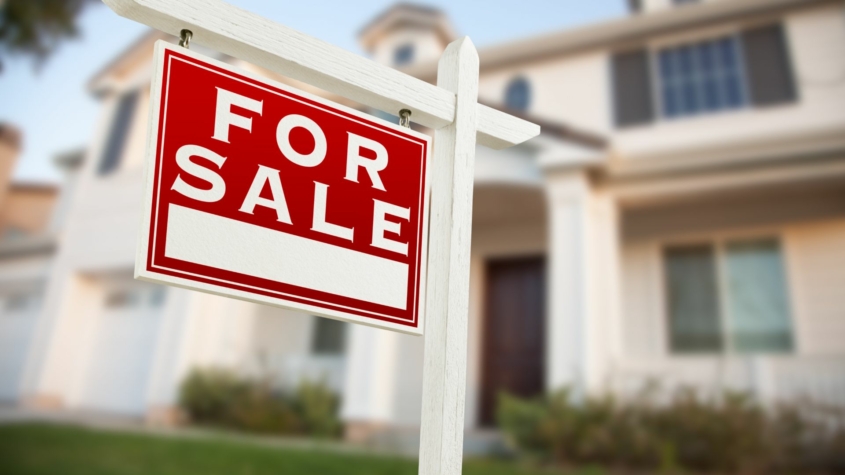 For sale home sign in front of a new construction home.