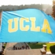 Schinal Harrington holds up a UCLA flag on her graduation day with her young daughter.