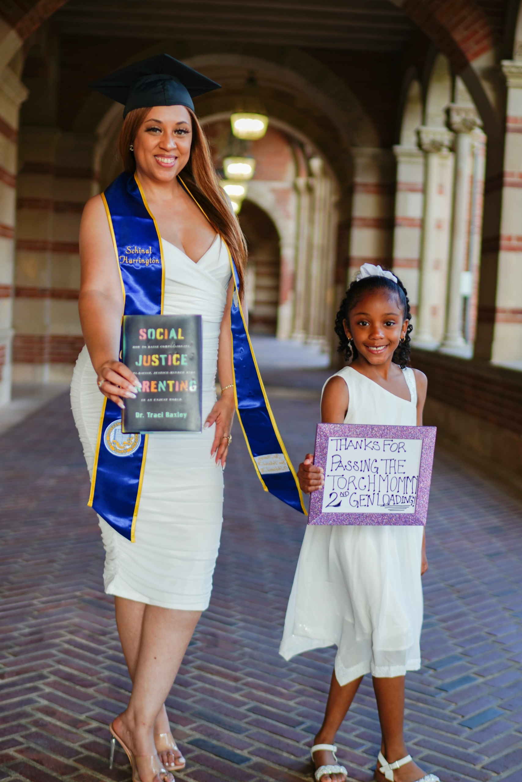 Schinal Harrington and Daughter Desi stand and pose with book "Social Justice Parenting"