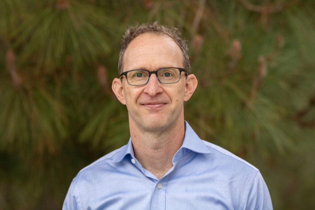 |portrait image of man with glasses and blue shirt