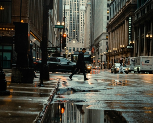 New York City street with pedestrian walking and cars driving by