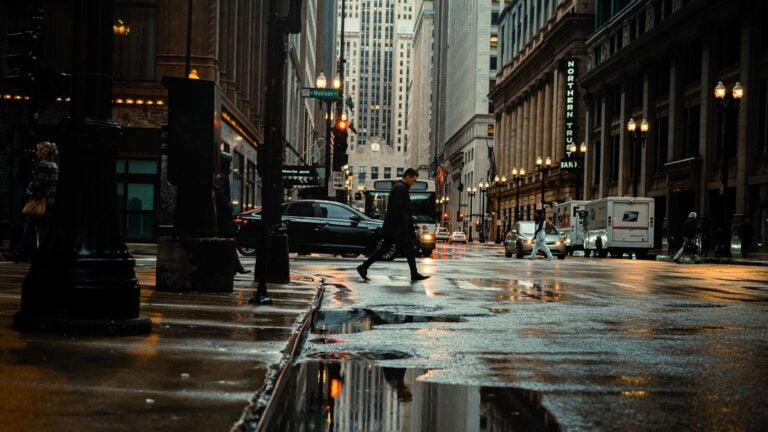 New York City street with pedestrian walking and cars driving by