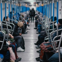People sitting inside a metro train.