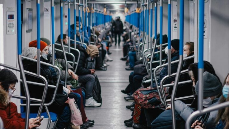 People sitting inside a metro train.