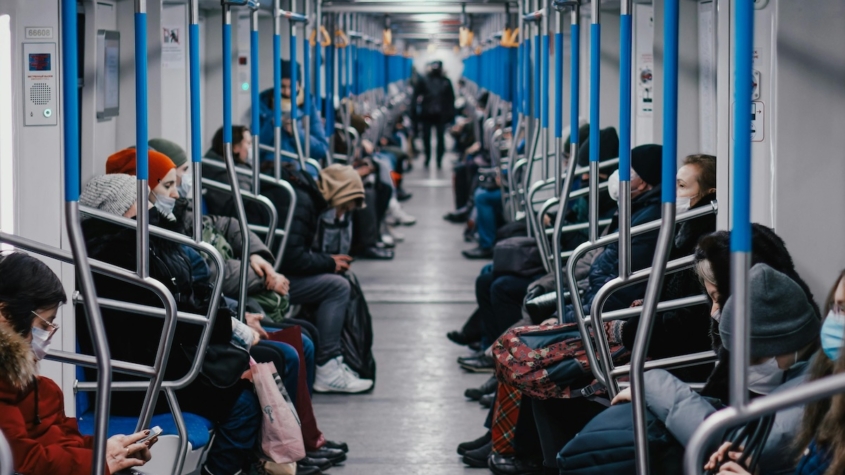 People sitting inside a metro train.