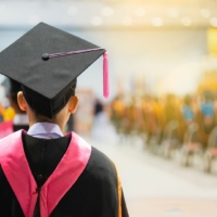 Back of a student in a graduation cap and gown.