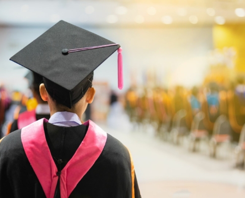 Back of a student in a graduation cap and gown.