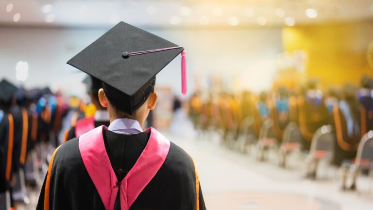 Back of a student in a graduation cap and gown.