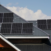 photo of a rooftop of a home with lots of solar panels on it.