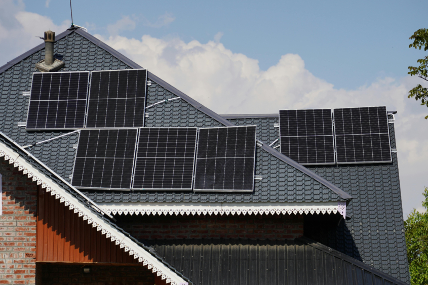 photo of a rooftop of a home with lots of solar panels on it.