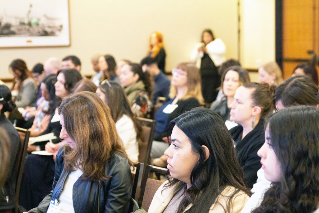 Attendees seated and listening to a presented at an academic event