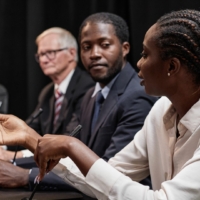 Budget proposal by karen bass Black Woman Posing Question to Colleague during Committee Session at Political Meeting