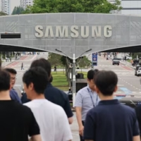 a crow od people walk below a Samsung sign.