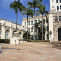 Vote center sign in front of ornate building and palm trees
