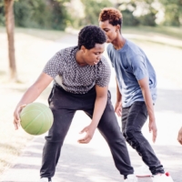 three boys are playing basketball