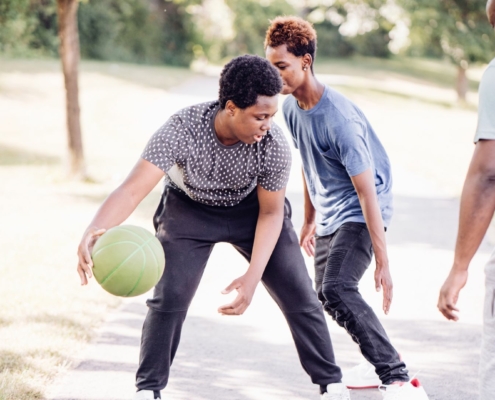 three boys are playing basketball