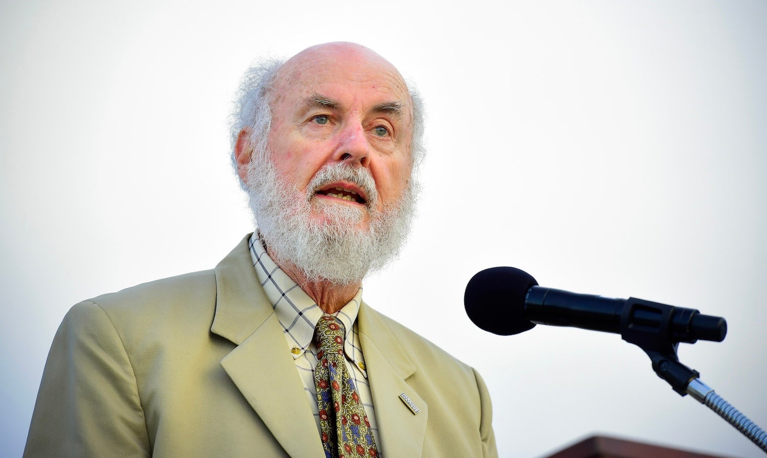 Man with white beard at podium