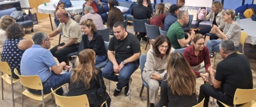 Visiting educators sit in concentric circles for one-on-one conversations
