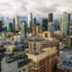 This photo captures the dense skyline of Downtown Los Angeles, featuring iconic skyscrapers like the U.S. Bank Tower and a prominent yellow construction crane.
