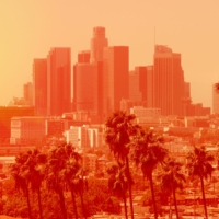Photo of Los Angeles downtown with palm trees on an extremely hot day, the photo is in a bright orange filter to indicate heat levels