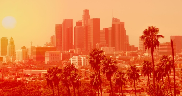 Photo of Los Angeles downtown with palm trees on an extremely hot day, the photo is in a bright orange filter to indicate heat levels