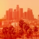 Photo of Los Angeles downtown with palm trees on an extremely hot day, the photo is in a bright orange filter to indicate heat levels