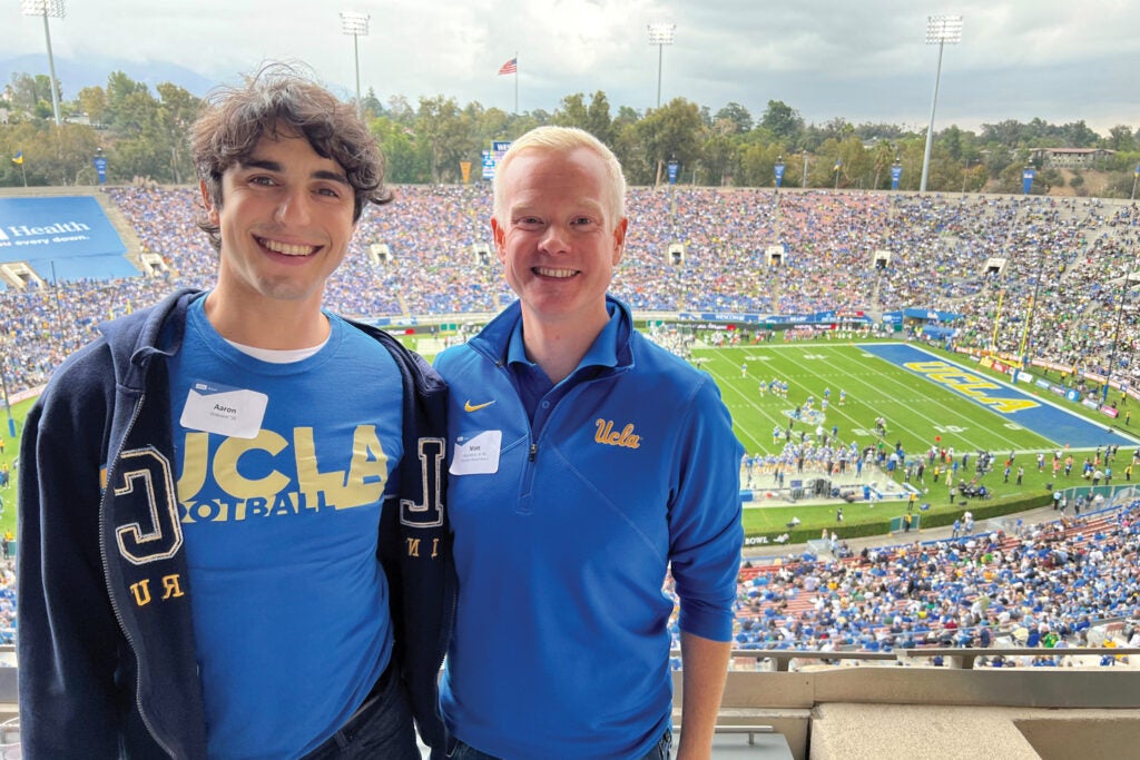 Two young men smiling at a football game