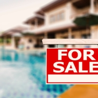 Backyard of a house with a swimming pool with "For Sale" sign