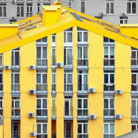 Pictures shows a cluster of buildings with one of them painted yellow, making it stand out