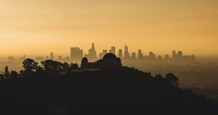 silhouette of Griffith Observatory set again orange sky and Los Angeles skyline