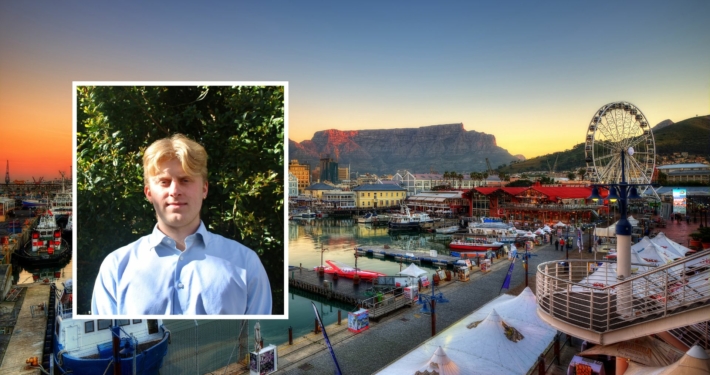 Cooper Emmott headshot over a landscape shot of Cape Town South Africa.