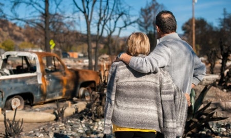 Couple checking ruins after fire disaster.