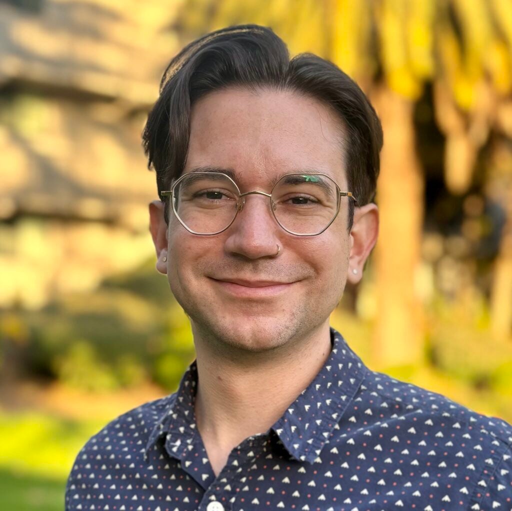 person in glasses, smiling, outdoors