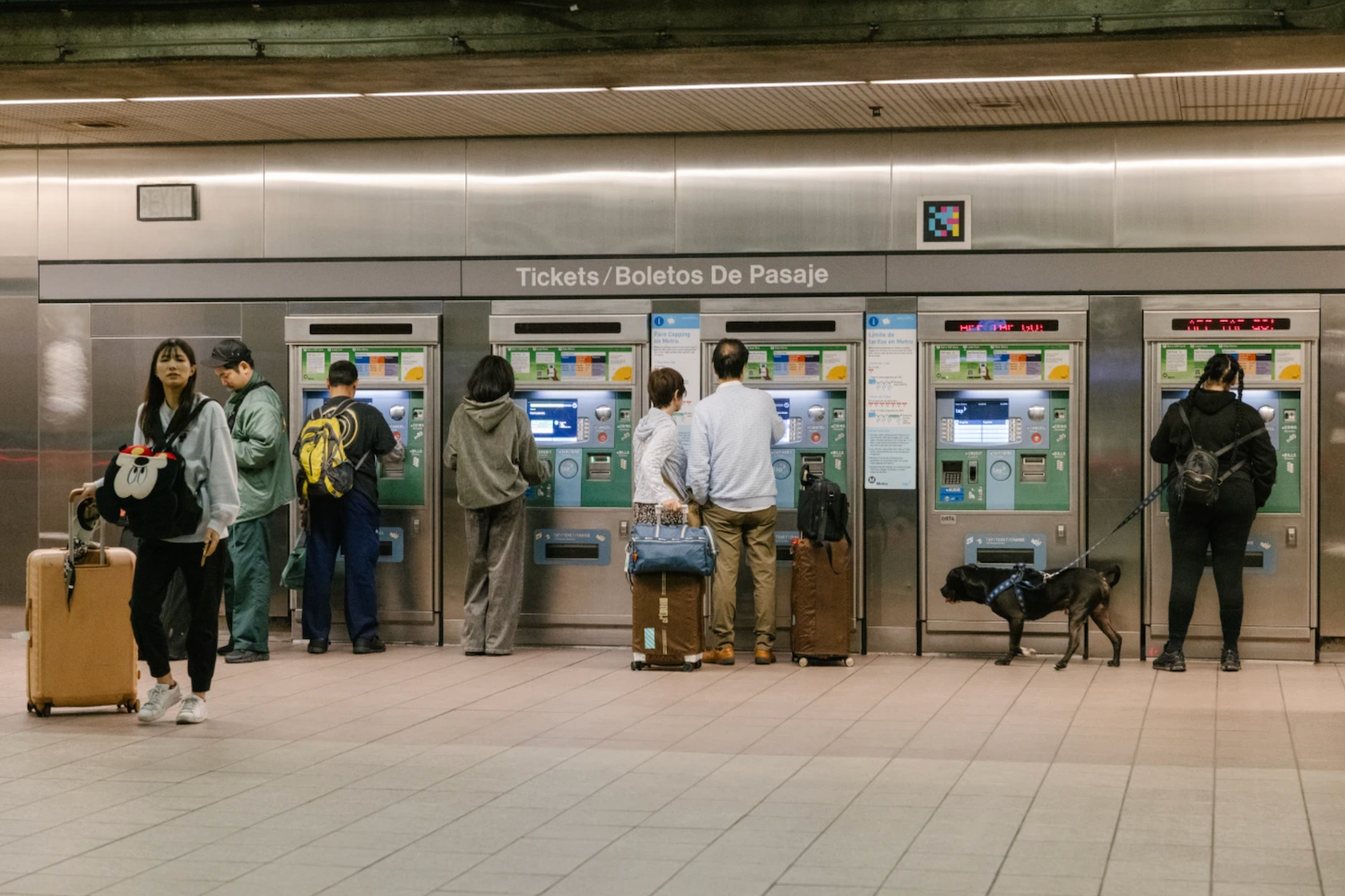 Transit riders purchase tickets at fare machines