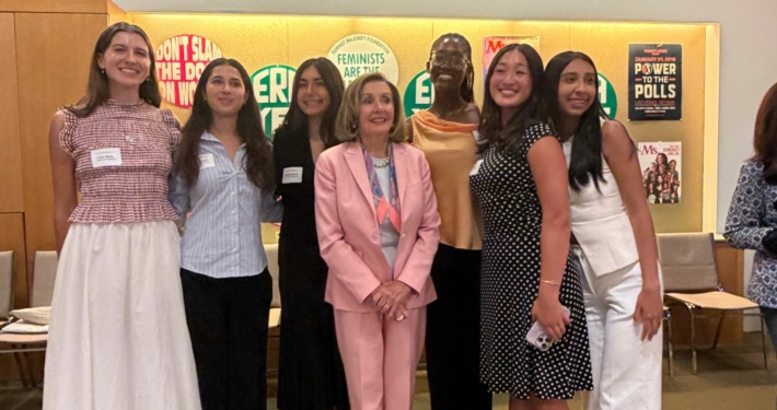 Luka Marks stands with Nancy Pelosi and group of women at Feminist Majority Foundation