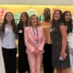 Luka Marks stands with Nancy Pelosi and group of women at Feminist Majority Foundation