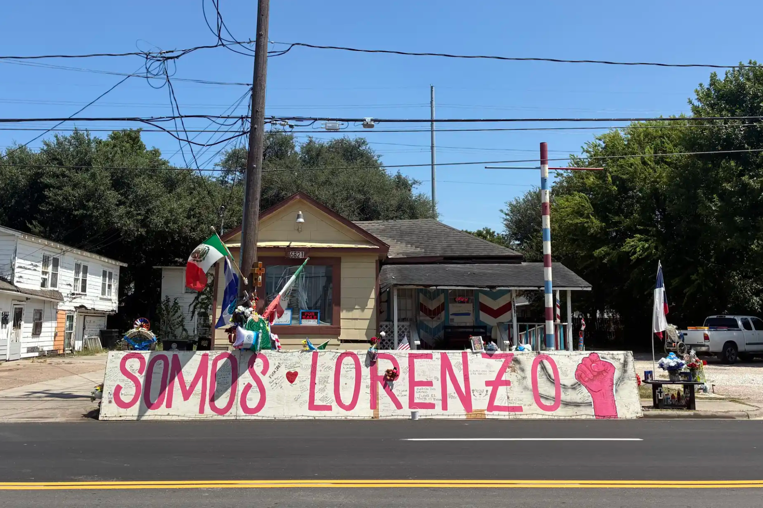 memorial in front of house with sign saying "Somos Lorenzo"