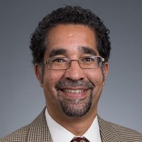 headshot of man with glasses in suit