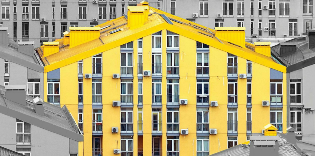 Pictures shows a cluster of buildings with one of them painted yellow, making it stand out