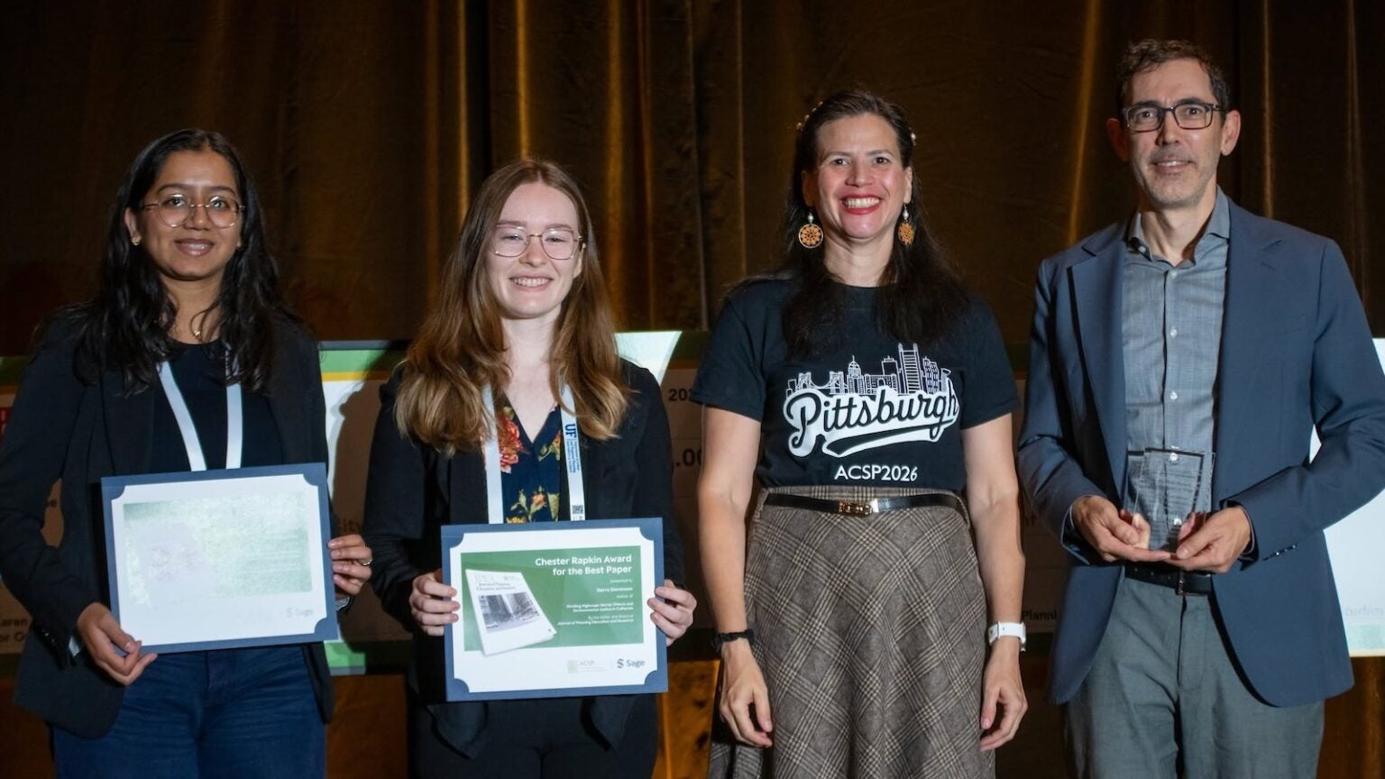 four people on stage holding awards