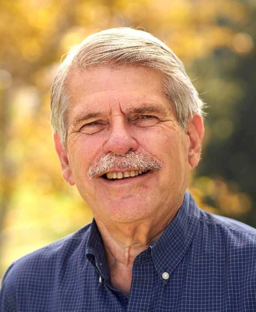 Man with moustache smiling outdoors