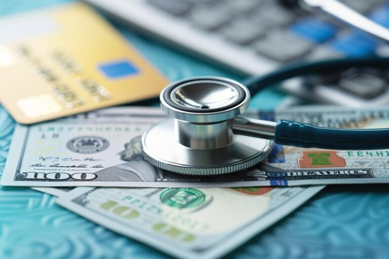 Stethoscope on money and credit cards, symbolizing medical costs