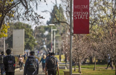 Students with backpacks walking outside at Fresno State campus