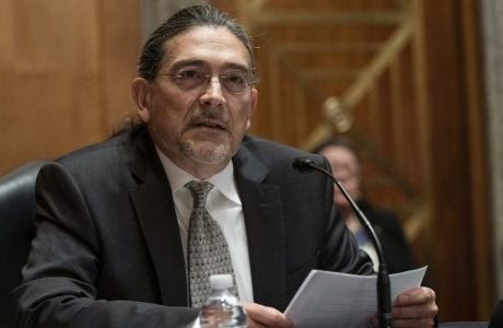 Census Bureau Director nominee Robert Santos wears glasses and a suit and sits at a podium on Capitol Hill.