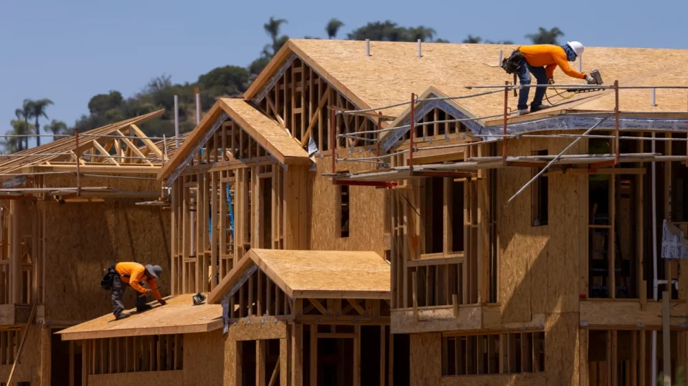 Construction worker builds the frame of a multi-story house.|