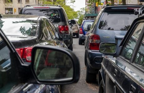 A line of double-parked cars on a New York City street.