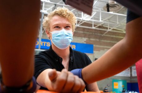Masked young man receiving vaccine