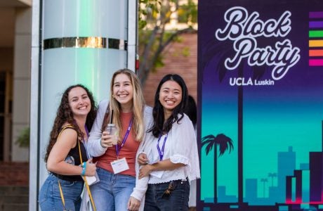 three women in front of "Block Party" sign