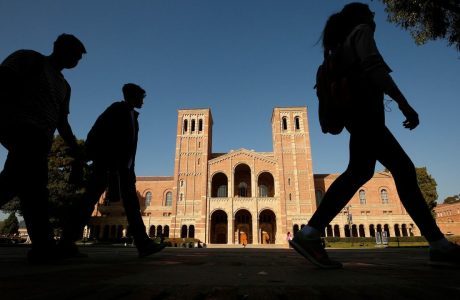 Silhouettes of students walk by in front of Royce Hall on UCLA campus.