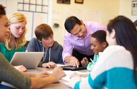teacher with students sitting at table
